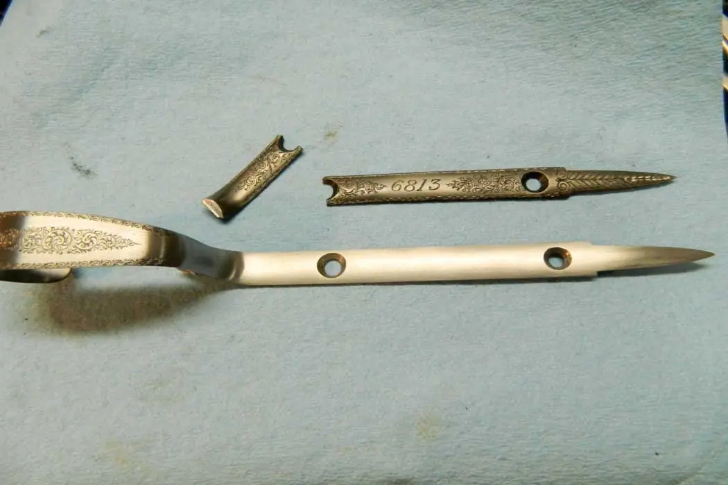 pieces of the original tail beside the fixed guard; the new tail ready to be cut and fused to the original trigger-guard bow