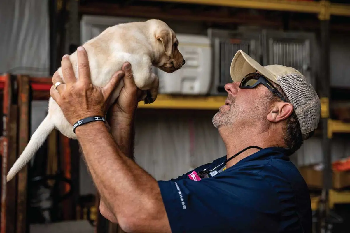 eukanuba-pro-trainer-chris-akin-holds-a-lab-puppy