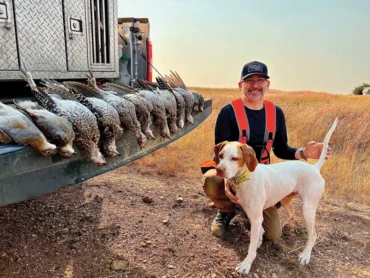 Man with dog and several birds they hunted