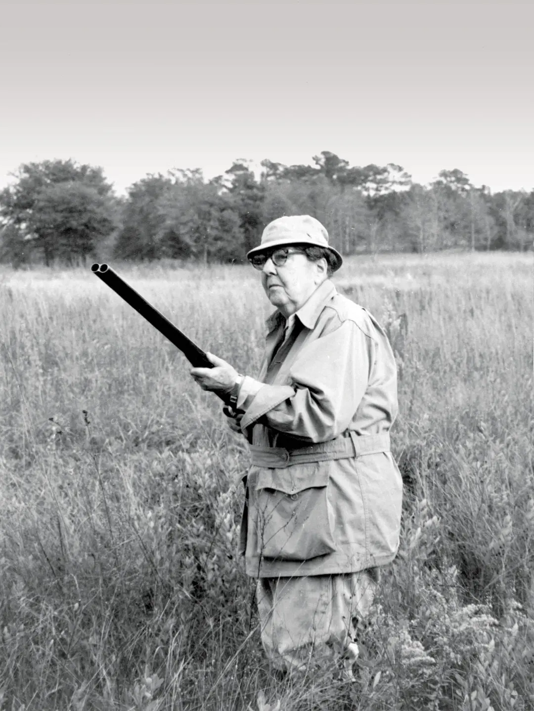black and white photo of a man with a gun in a field