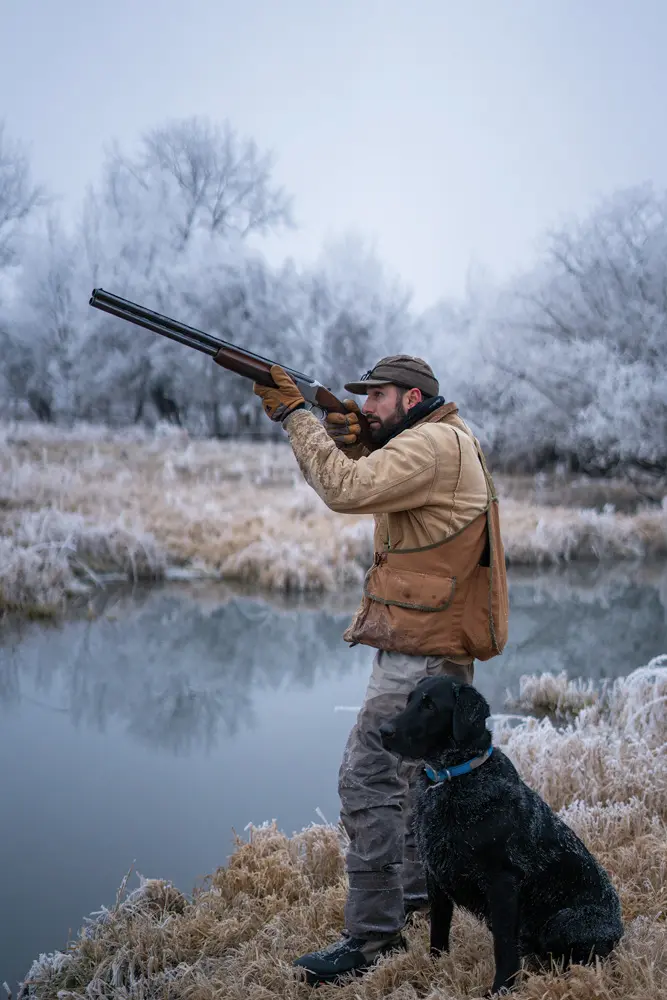 hunter taking aim with his dog
