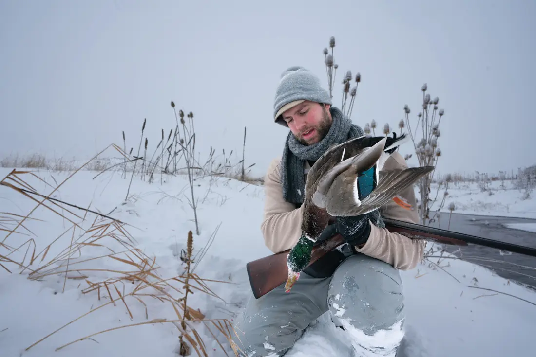 hunter with bird in the snow