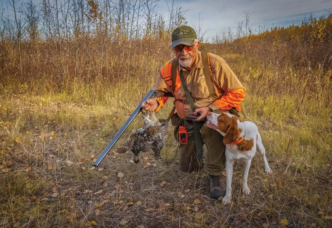 Jim McCann with his two young dogs and a brace of sharptails taken in a wildfire-burn area.