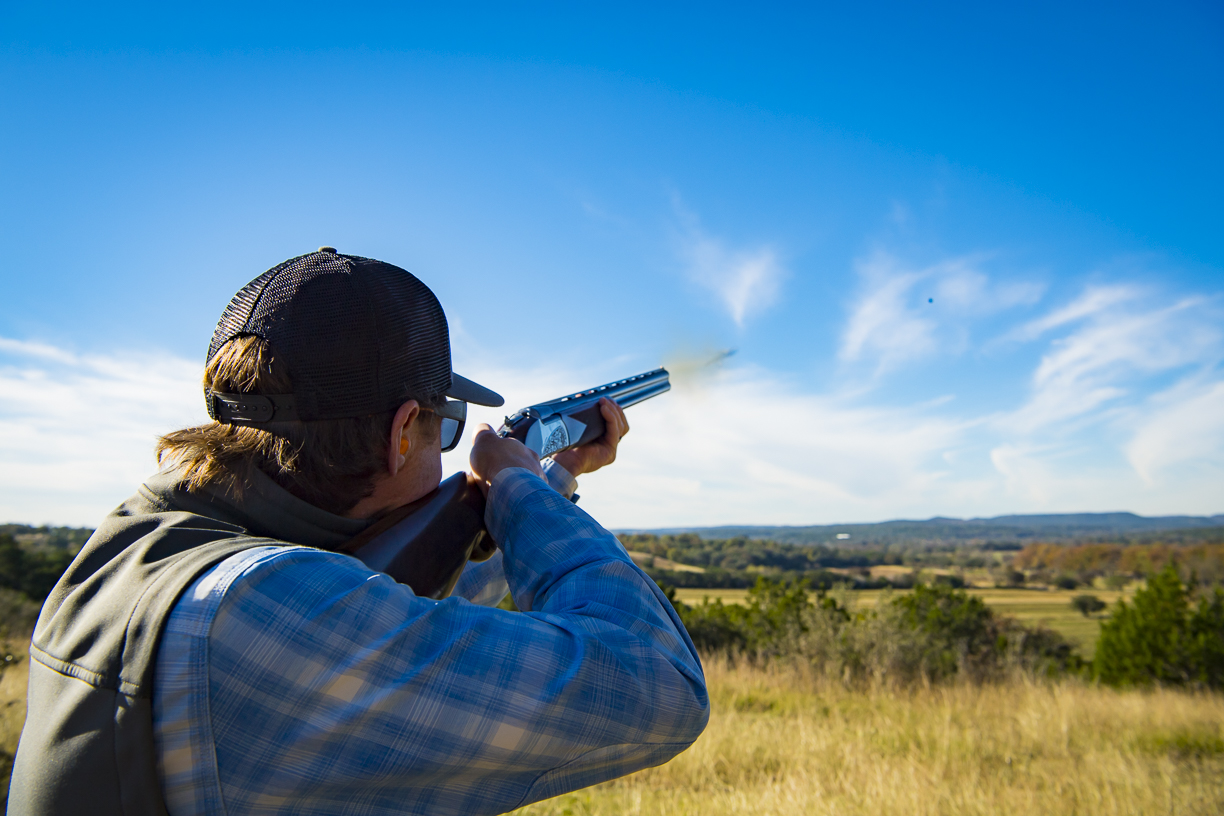 A hunter firing at a bird in flight