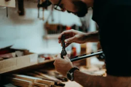 A gunsmith works on the barrel of a shotgun.